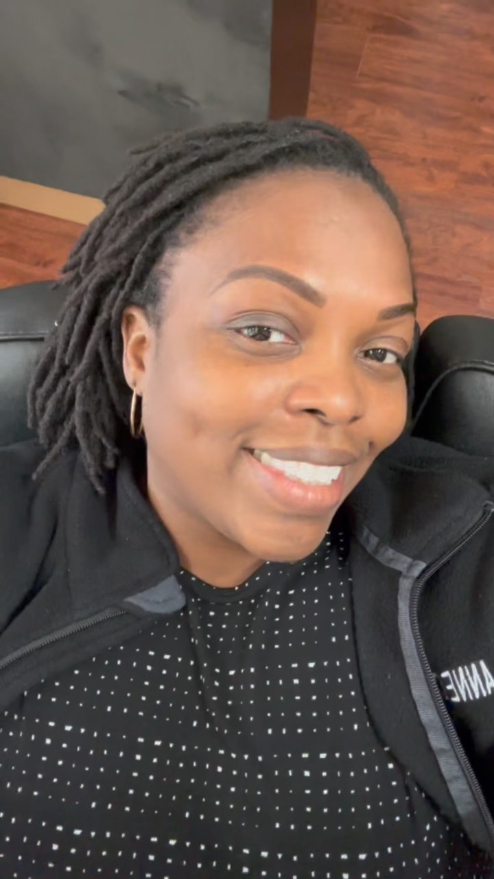 A client smiles in the studio chair after her appointment.
